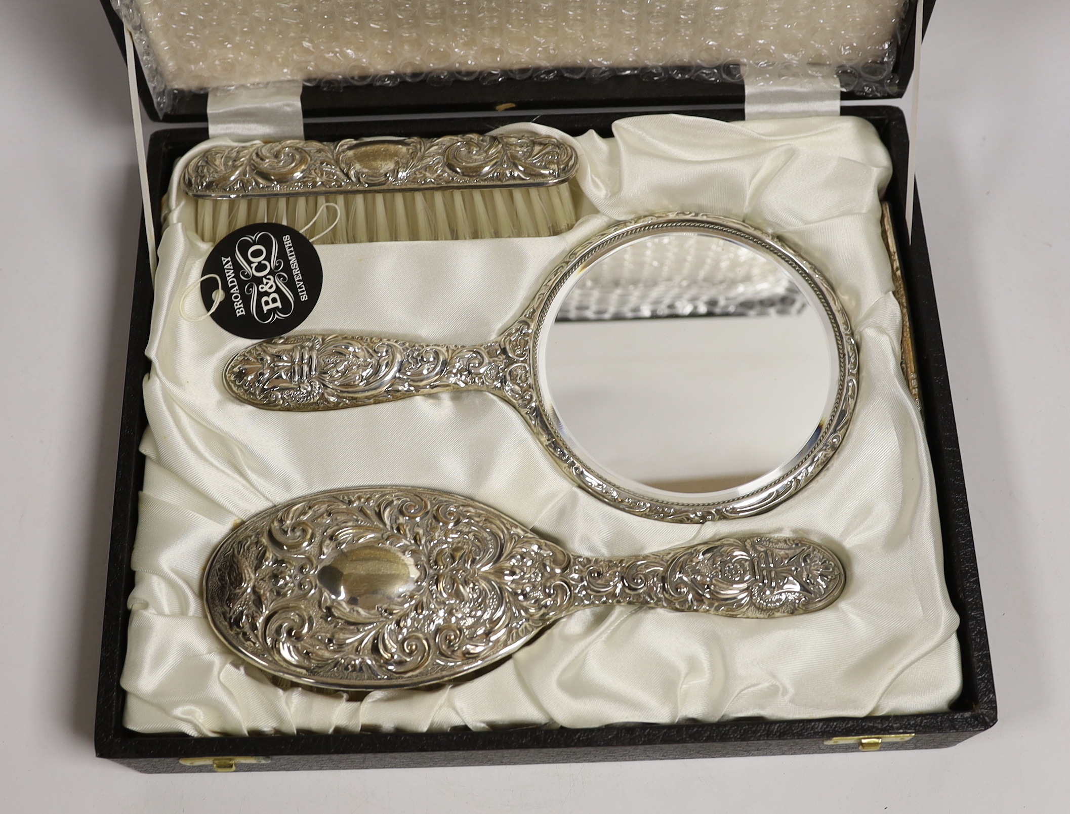 A cased modern silver mounted four piece mirror and brush set, Birmingham, 1985.
